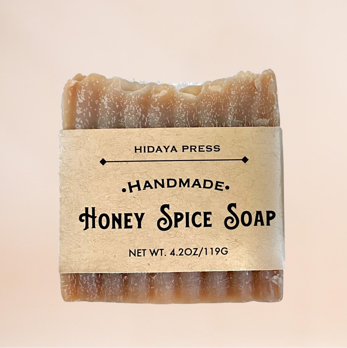 Handmade honey spice soap bar with 'Hidaya Press' label on a beige background