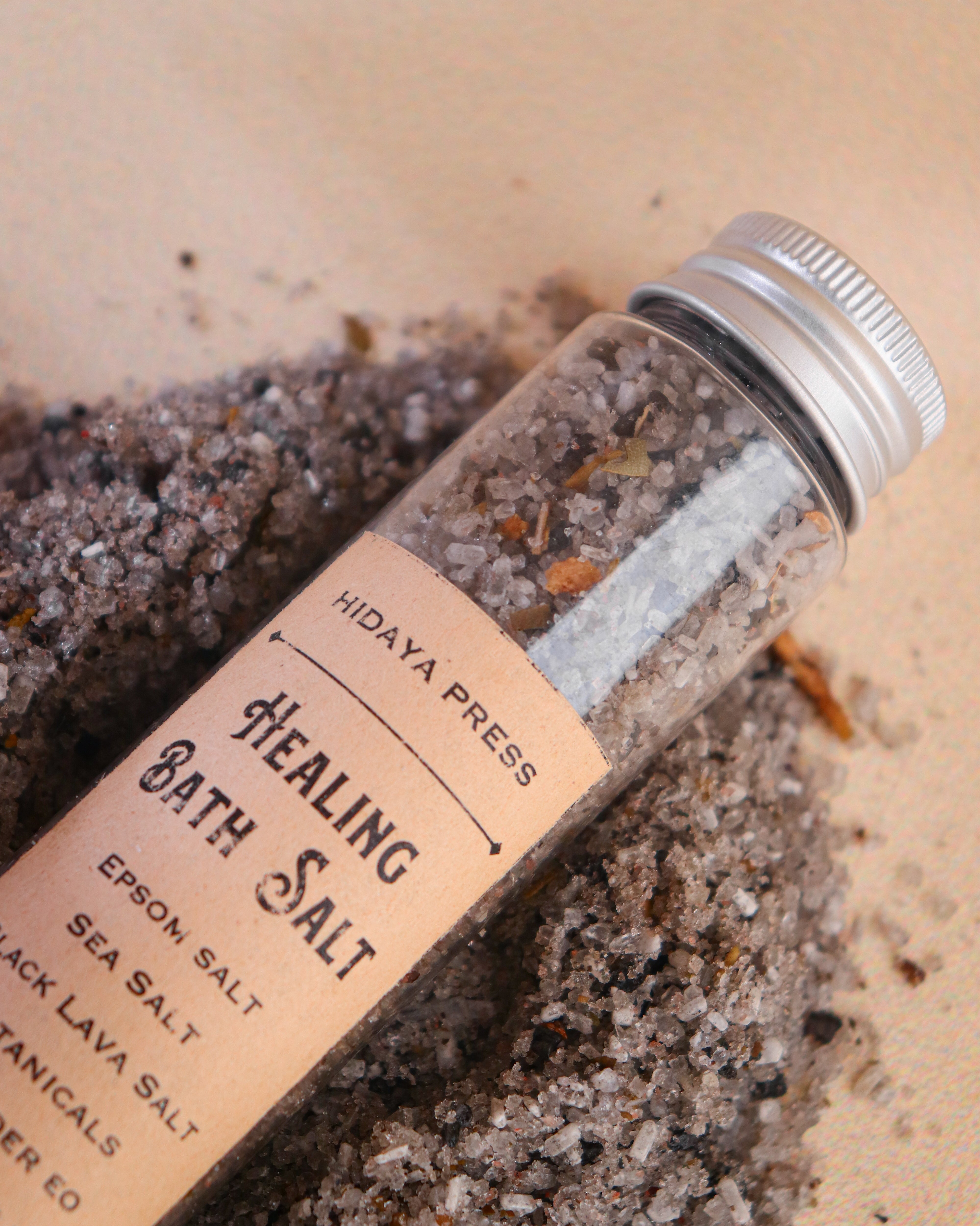 Bottle of 'Healing Bath Salt' with a label on a beige background