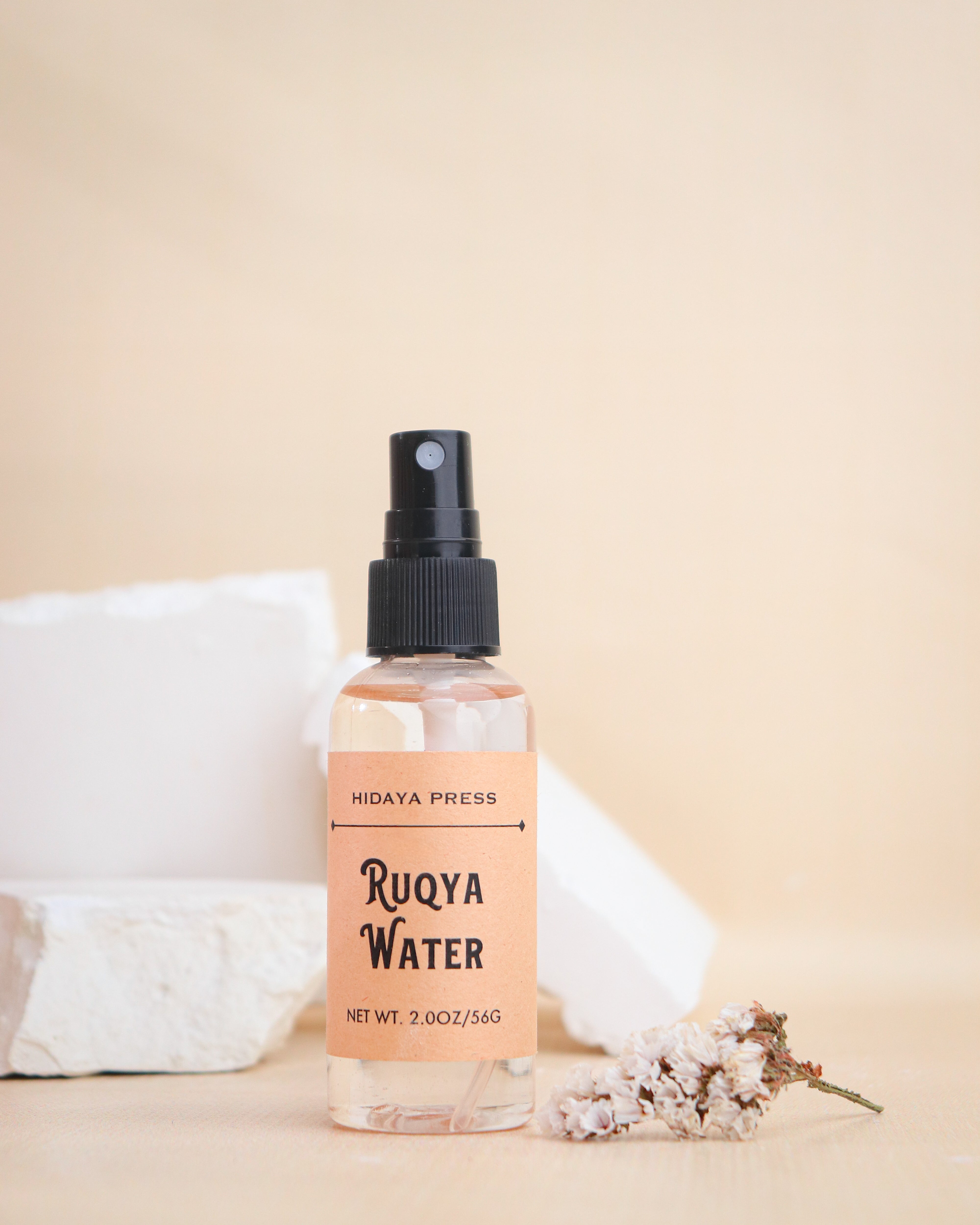Bottle of Ruqya Water with a beige label on a beige background
