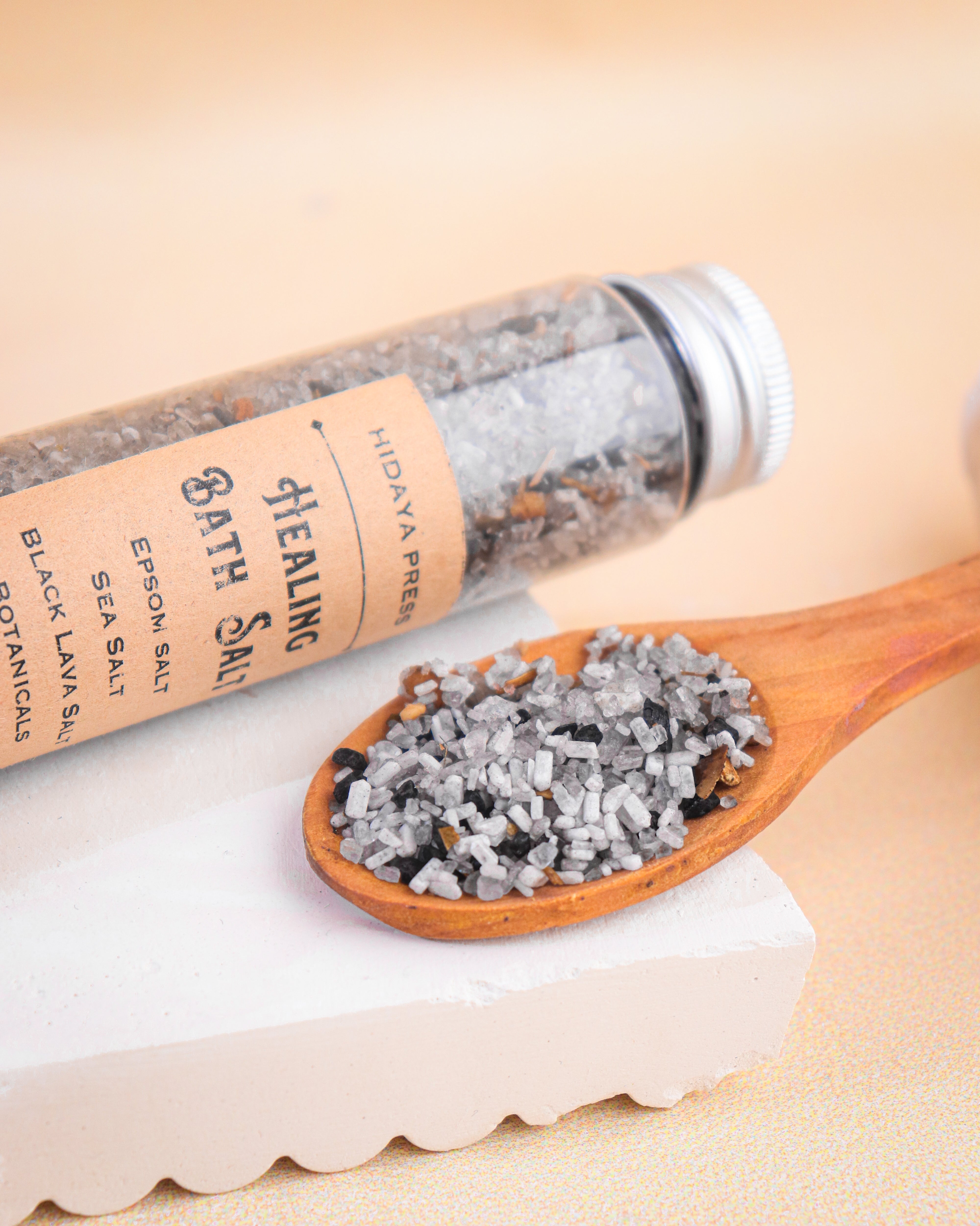 Healing bath salt with a wooden spoon on a beige background