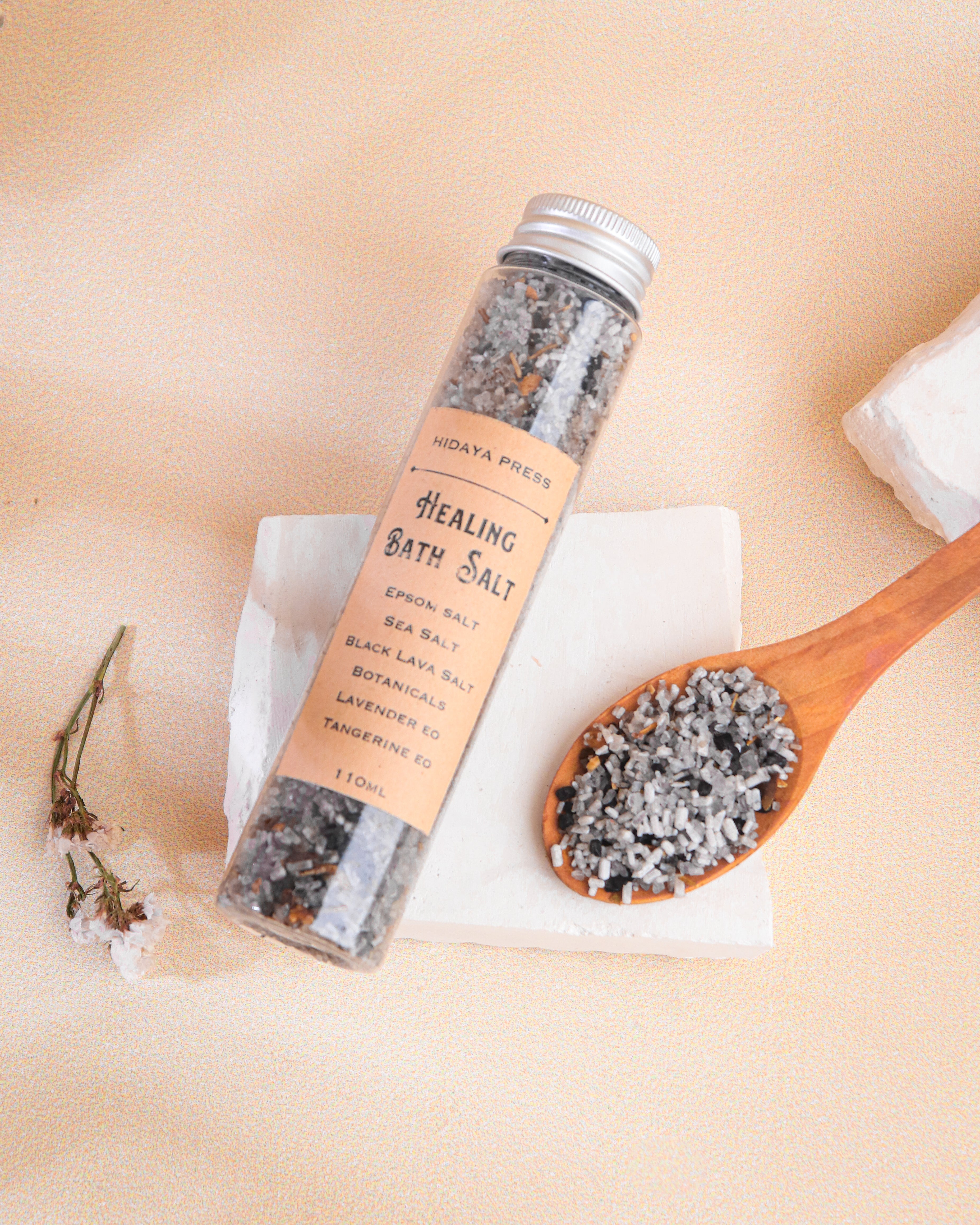 Healing bath salt container with a wooden spoon filled with salt on a beige background